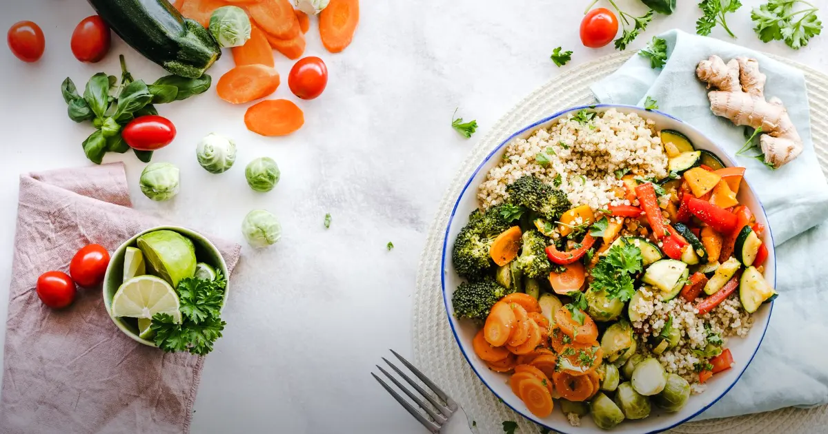Prato de legumes com quinoa, ao lado de gengibre, limão e tomates